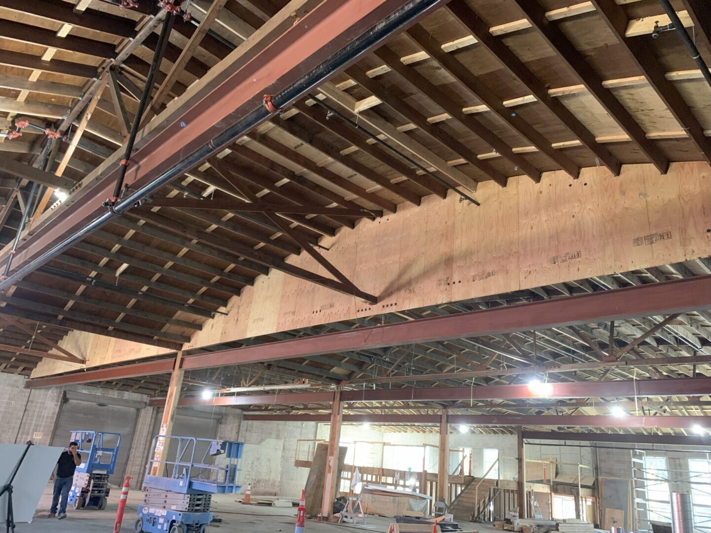 Construction site with exposed ceiling beams and steel framework.